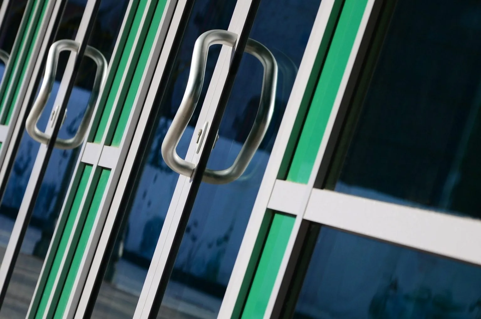 Chrome door handle and glass of modern aluminium door outside the office building